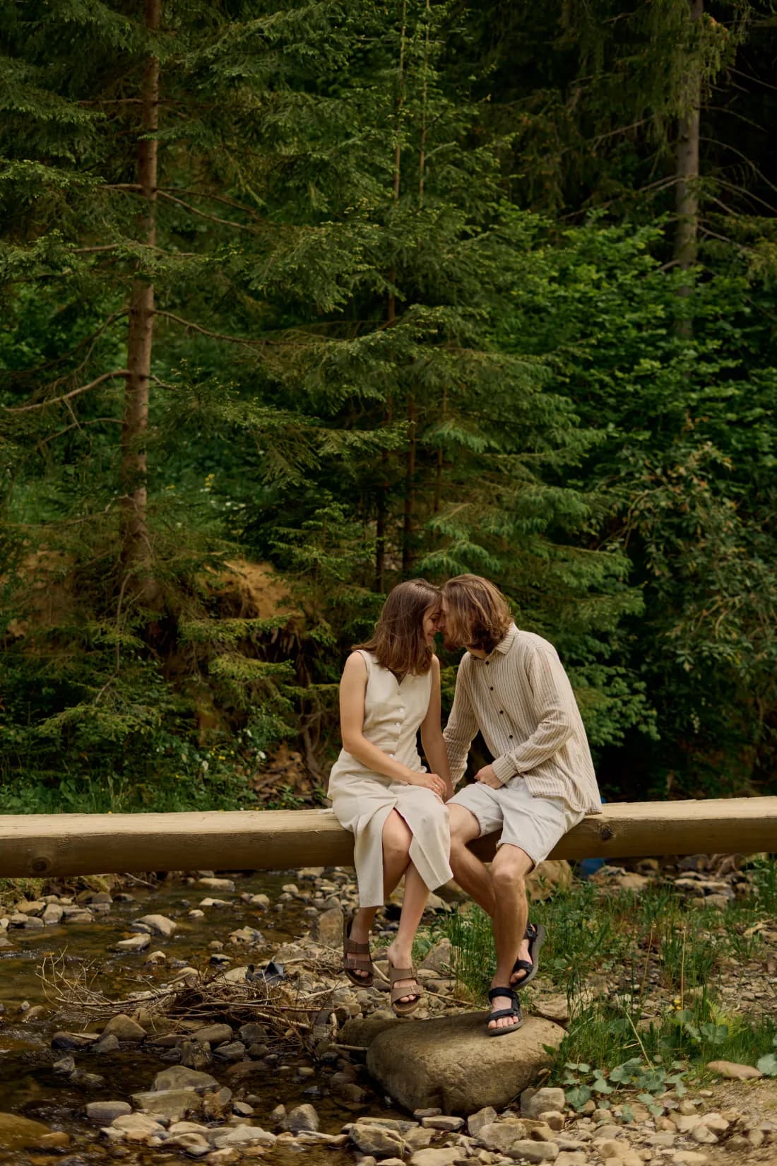 Couple sitting together near a forest stream